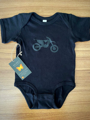black baby onesie with a black butterfly dirt bike on it