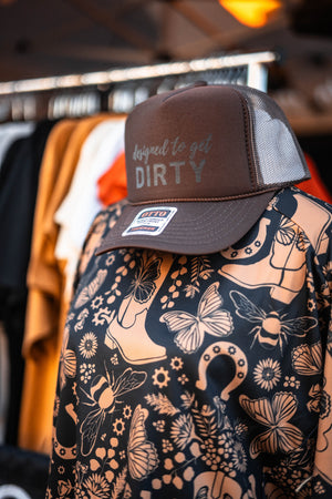 Brown cap with text on a patterned shirt with boots and butterflies