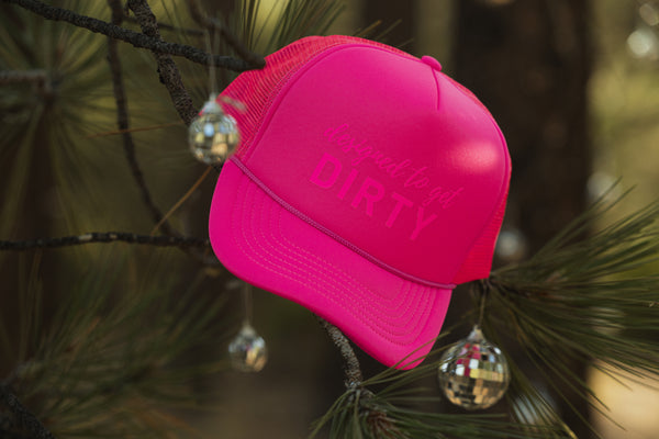 Hot pink trucker hat with designed to get dirty written on the front