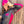 Load image into Gallery viewer, Woman wearing a black and pink outfit with a matching beanie against a wooden background
