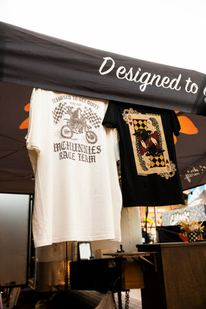 T-shirts with designs hanging under a canopy labeled 'Designed to get dirty'