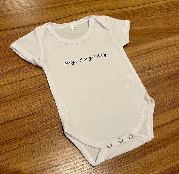 baby onesie with designed to get dirty written across the front in black cursive