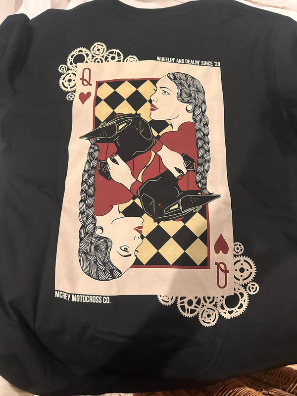 Black shirt featuring a playing card on the back with a girl holding her dirt bike helmet. It says 'Wheelin and Dealin since 20'