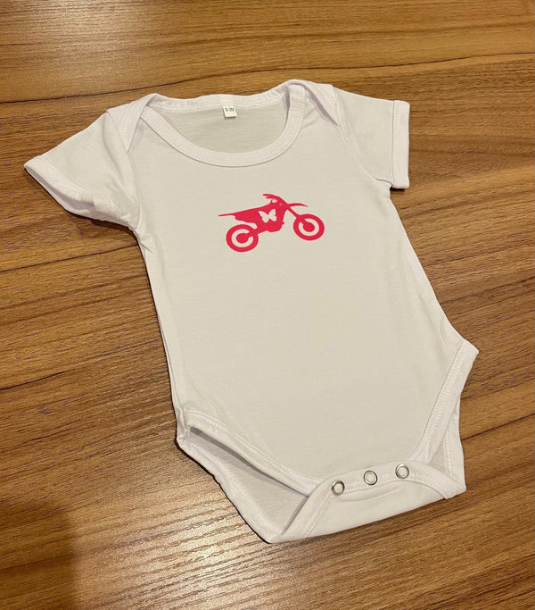 baby onesie with a hot pink dirt bike and mcrey butterfly on the front