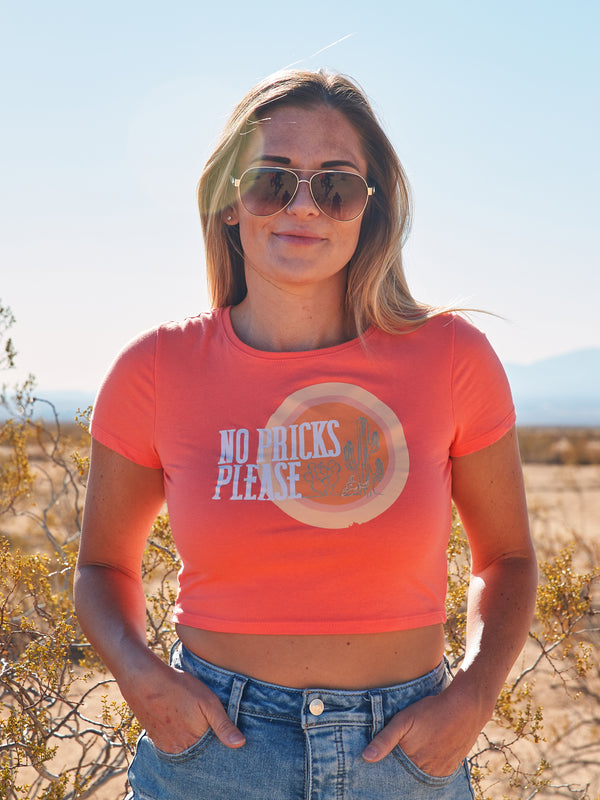 coral crop top with a sun, cactus and bull skull on the front. No pricks please.
