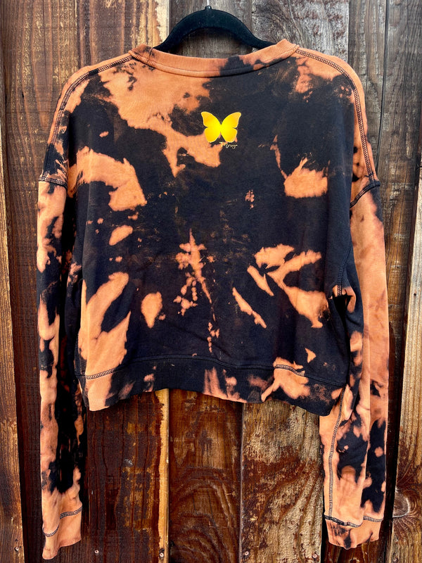 Women's cropped crewneck sweatshirt. It's black with bleach tie-dye. It has a small butterfly on the back.