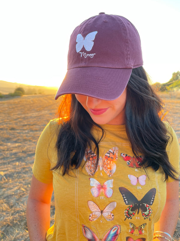maroon dad cap with a white butterfly stitched on the front