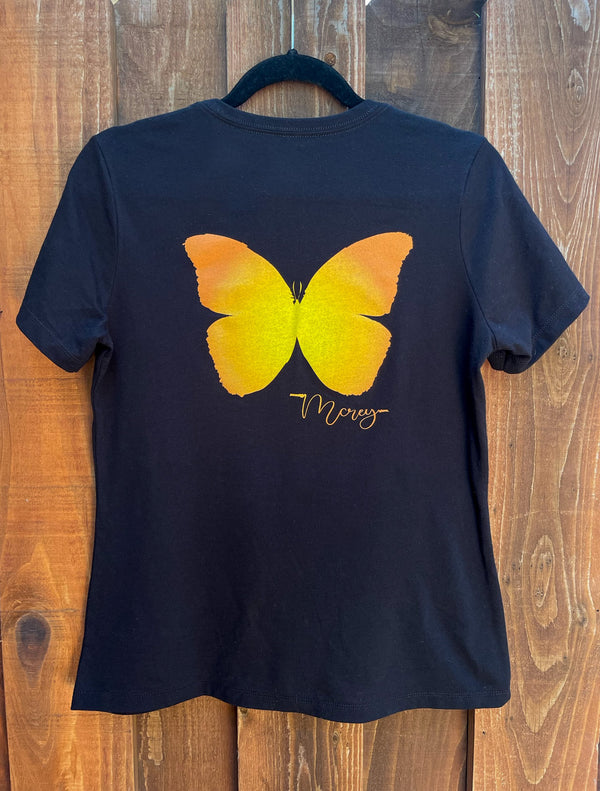 Back of a women's black t-shirt with an orange and yellow butterfly on the back.