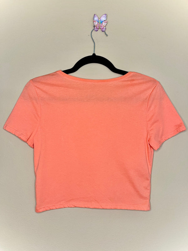 coral crop top with a sun, cactus and bull skull on the front. No pricks please.
